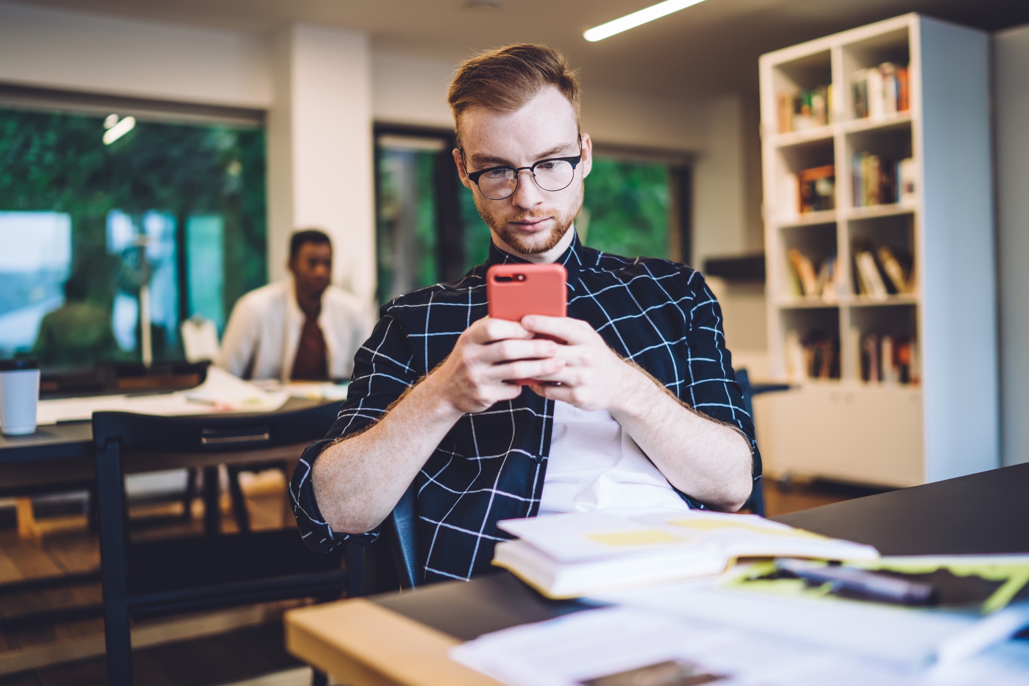 Focused student using smartphone in library