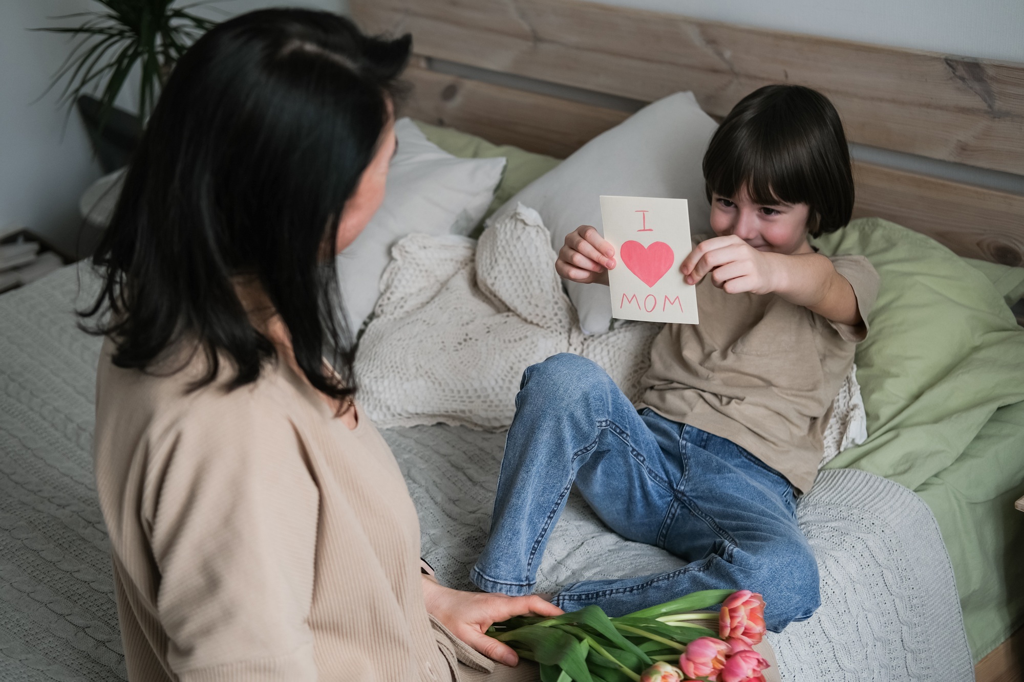Loving little son gives his mother a card "I love mom"